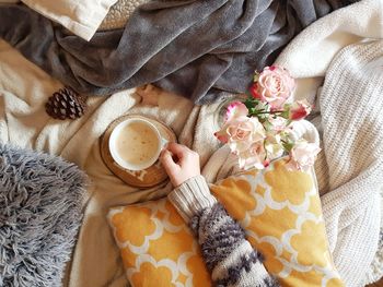 Overhead photo of hand holsdimg coffee cup. warm and cozy lifestyle.