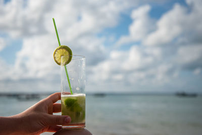 Close-up of drink on table against sea