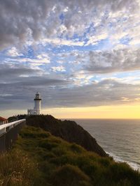 Lighthouse by sea against sky