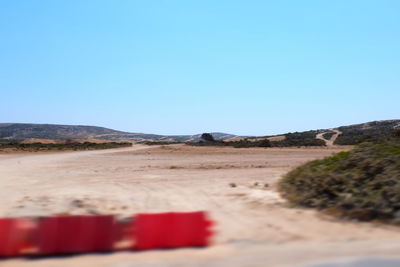 Surface level of railroad tracks against clear blue sky