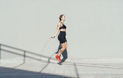 Young athlete skipping rope on sunny day