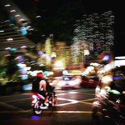 Blurred motion of people walking on road at night