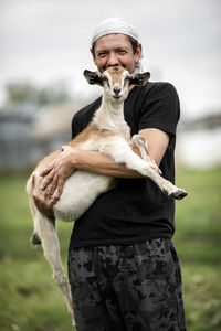 Local agriculture, farmer's day 12 october. a man with a goat in his arms,  natural products.