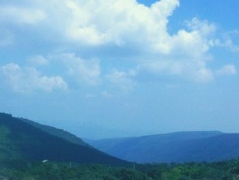 Scenic view of mountains against cloudy sky