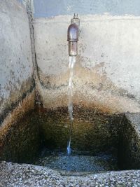 Water spraying from fountain against wall