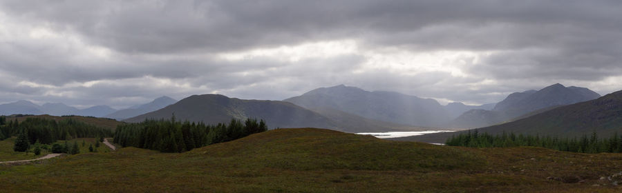 Scenic view of mountains against cloudy sky