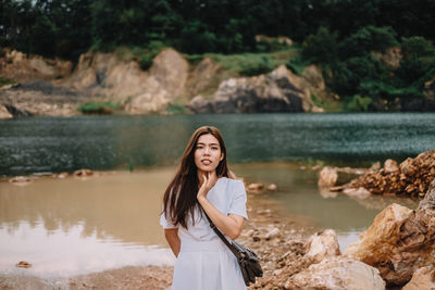 Portrait of woman standing against water