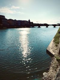 Scenic view of river by buildings against sky