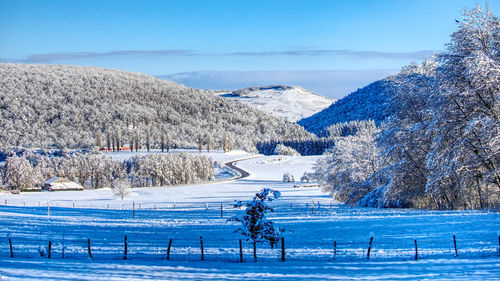 Scenic view of snowcapped mountains against blue sky