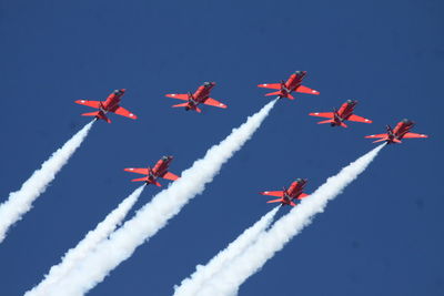 Low angle view of airplane flying against blue sky