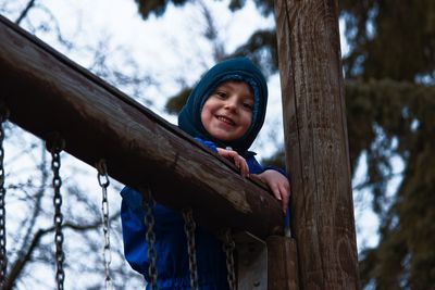 Portrait of smiling boy standing on footbridge