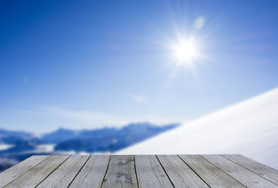 Sunlight falling on pier against blue sky on sunny day