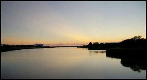Scenic view of calm lake at sunset