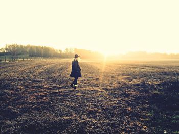 Silhouette of people on field at sunset