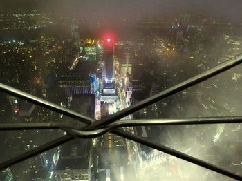 Illuminated city by river at night
