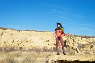 Full length portrait of woman standing on land against sky