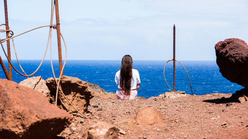 Rear view of woman looking at sea shore against sky