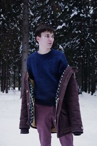 Young man wearing warm clothing while standing on snow