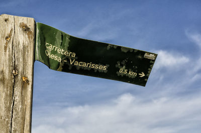 Low angle view of damaged signboard against sky