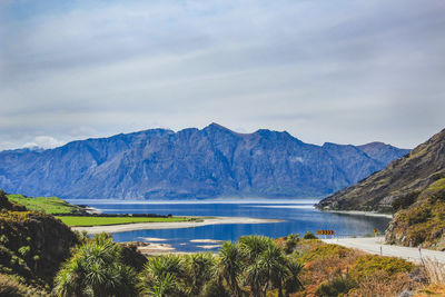 Scenic view of lake by mountains against sky