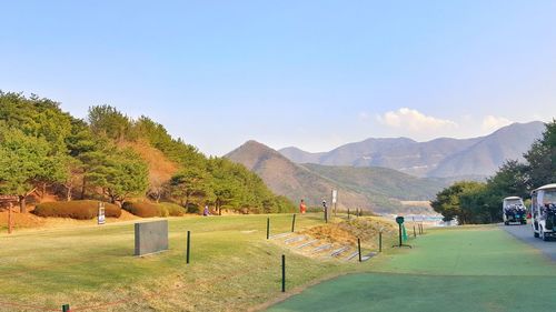 Scenic view of field and mountains against clear sky