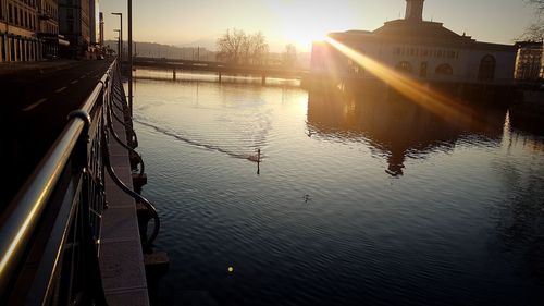 Silhouette of bridge over river in city