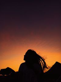 Silhouette woman standing against sky during sunset