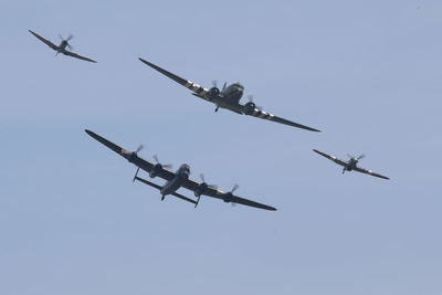 Low angle view of airshow against clear sky