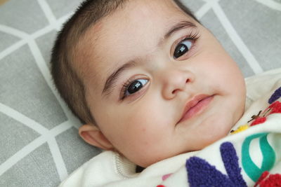 Portrait of cute baby lying on bed