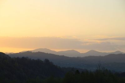 Scenic view of silhouette mountains against sky at sunset