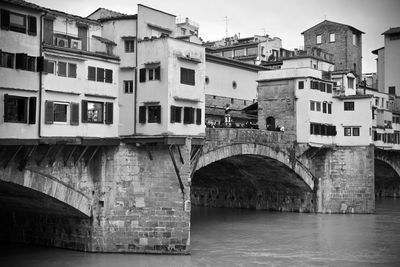 Bridge over river by buildings in city