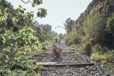 Man standing by railroad tracks against sky