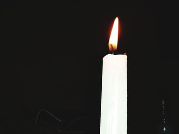 Close-up of illuminated candle against black background