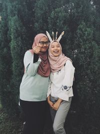 Young couple standing against plants