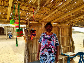 Portrait of smiling man standing by hut