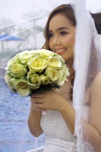 Portrait of a smiling young woman holding bouquet