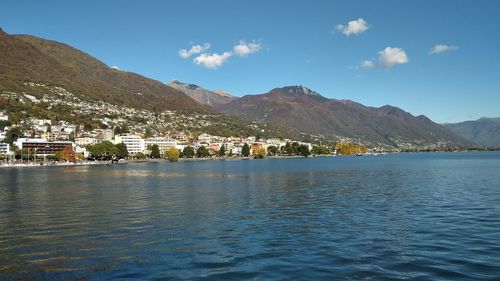 Scenic view of sea by buildings against sky