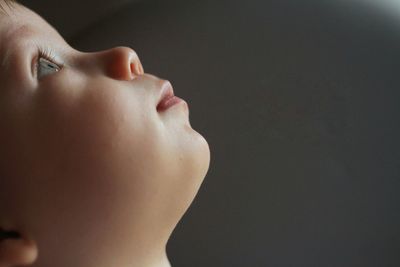 Close-up of boy against black background