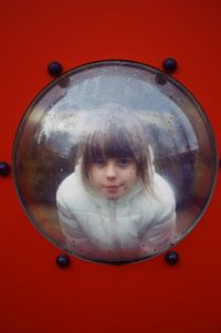 Close-up portrait of girl in red mirror