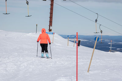 Rear view of man skiing on field against snowcapped mountain