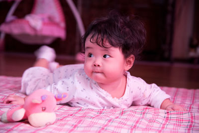 Close-up of cute baby lying on blanket