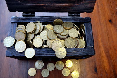 High angle view of coins in wooden box on table