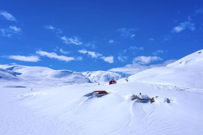 Scenic view of snowcapped mountains against blue sky