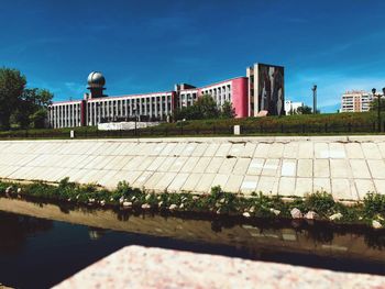 View of swimming pool by building against sky