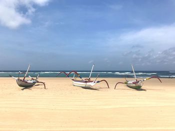 Boats moored on beach against sky