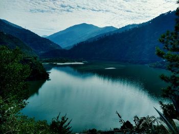 Scenic view of lake by mountains against sky