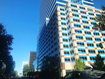 Low angle view of modern buildings against clear blue sky