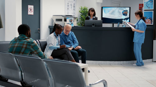 Rear view of people working at airport