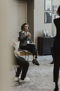 Mature businesswoman discussing with male and female colleagues at corporate office