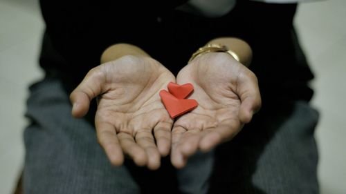 Midsection of man holding heart shape
